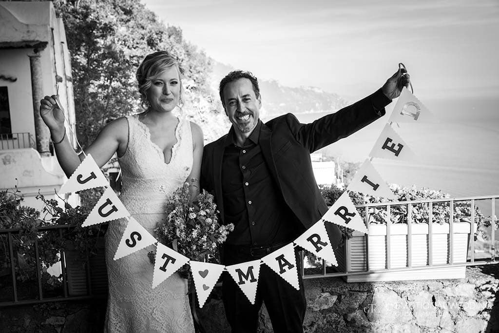 bride and groom showing a banner with an inscription just married in Amalfi Coast
