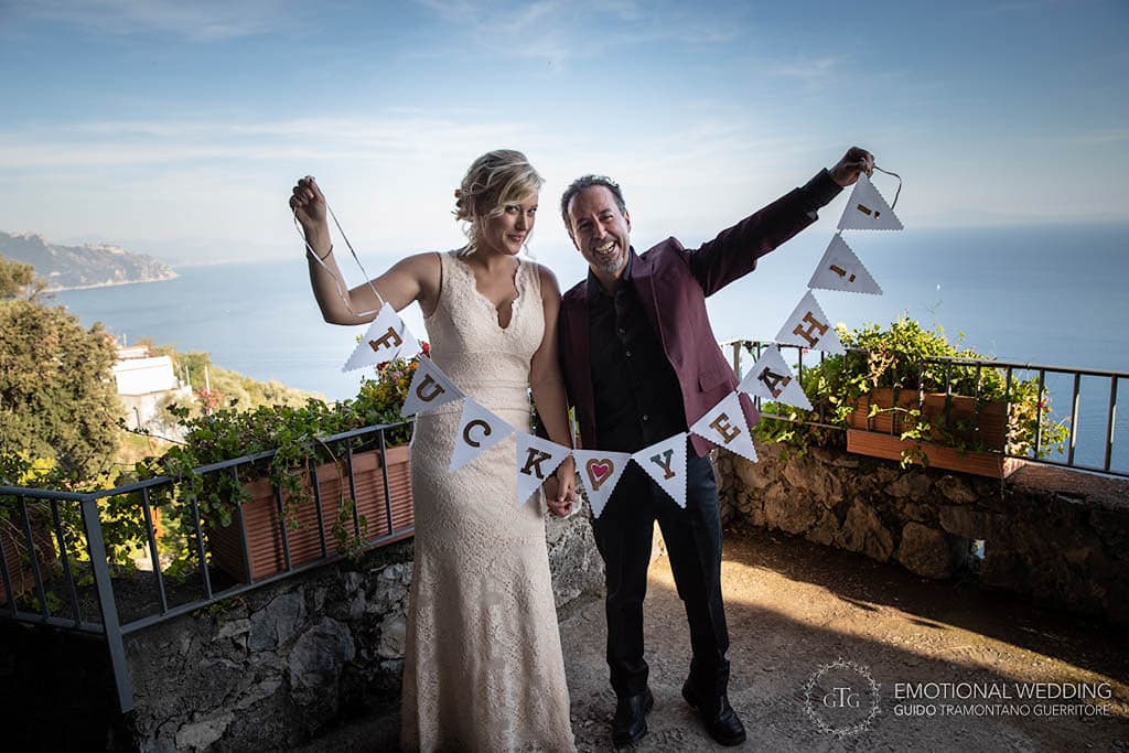 bride and groom showing a banner at their elopement on the Amalfi Coast