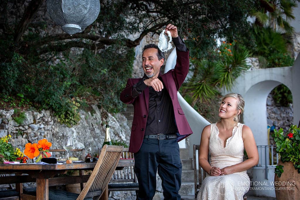 groom cheering after taking off the bride's garter at their elopement in Amalfi Coast