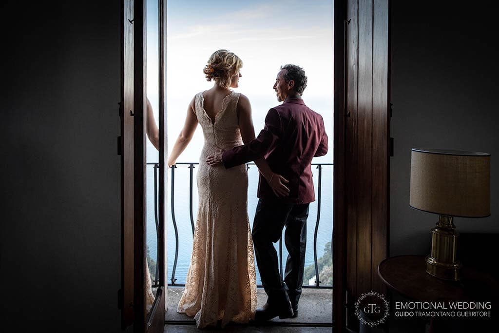 sposi affacciano sul balcone dell'albergo ad un elopement in costiera amalfitana