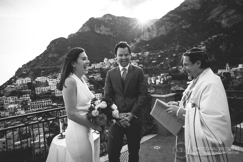 bride and groom and officiant laugh during wedding ceremony in Positano
