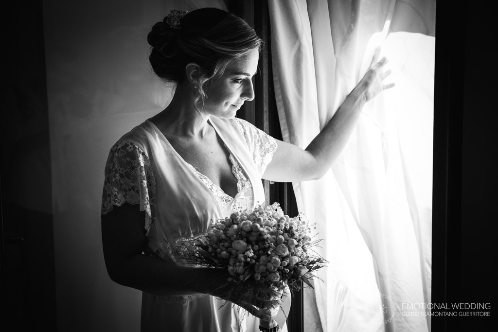 bride getting ready looking out of the windows at a wedding in Napoli