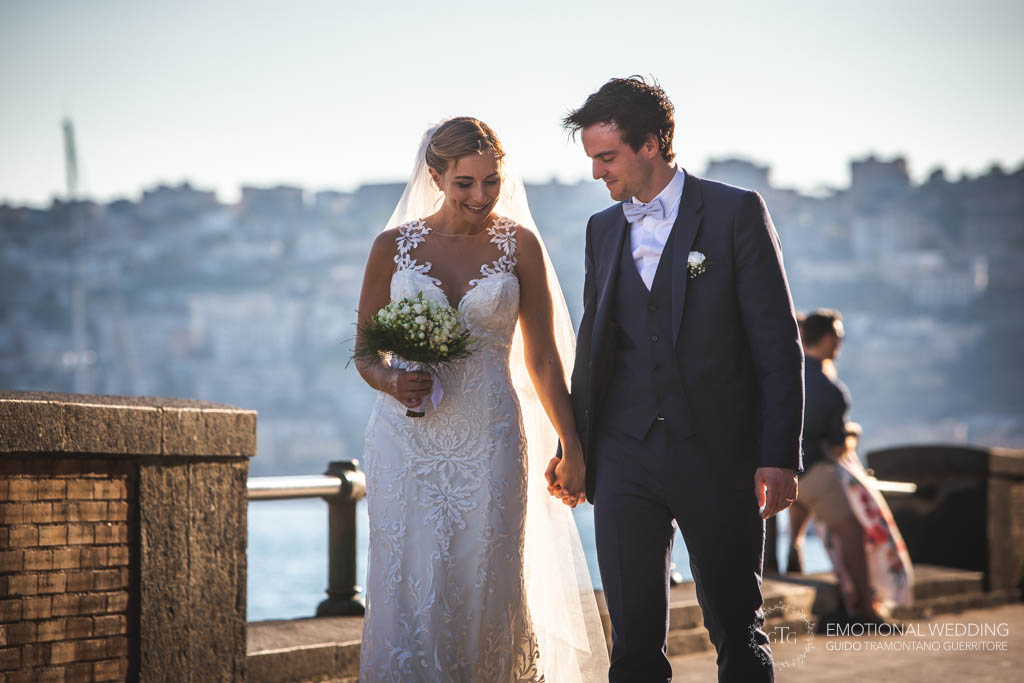 candid shot of the bride and groom walking in napoli seafront