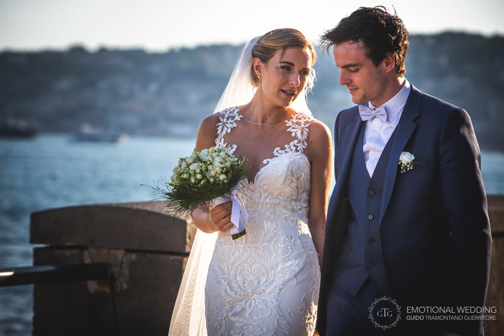 sposi passeggiano sul lungomare a un matrimonio a Napoli