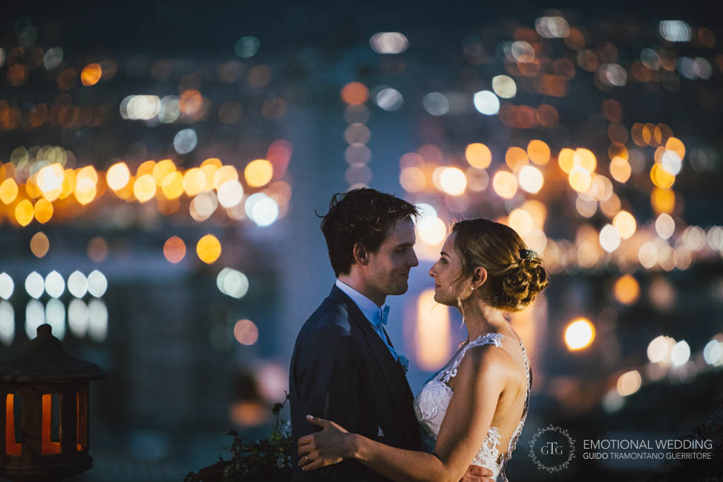 ritratto di una coppia di sposi di notte con luci della città sullo sfondo all'hotel san Francesco al monte a Napoli durante il ricevimento di matrimonio