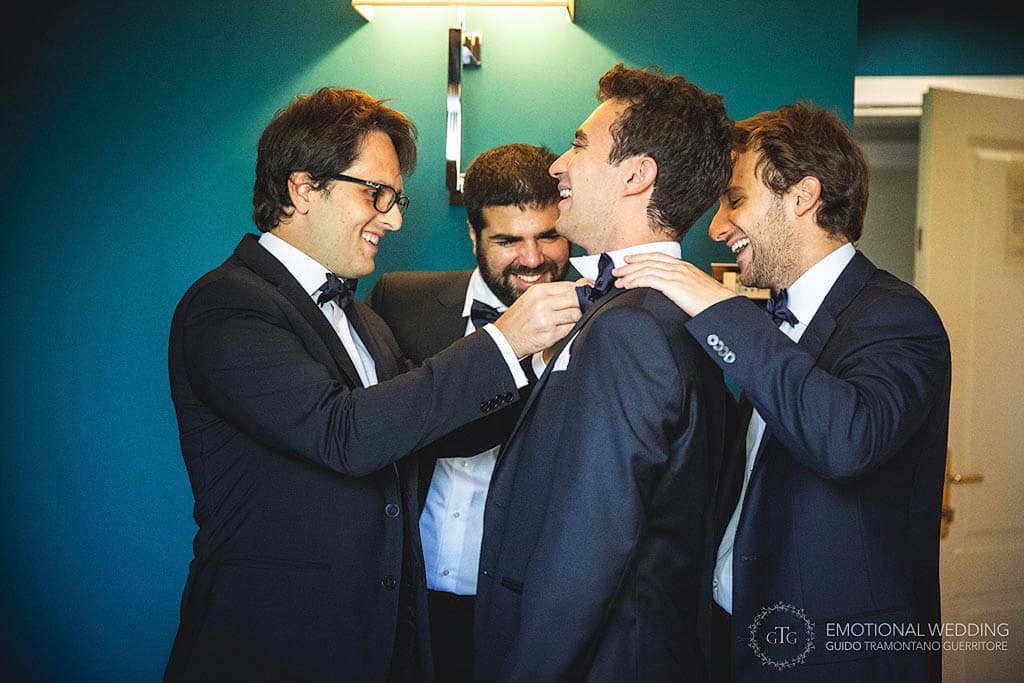 candid of the groom and best men getting ready at a wedding in puglia