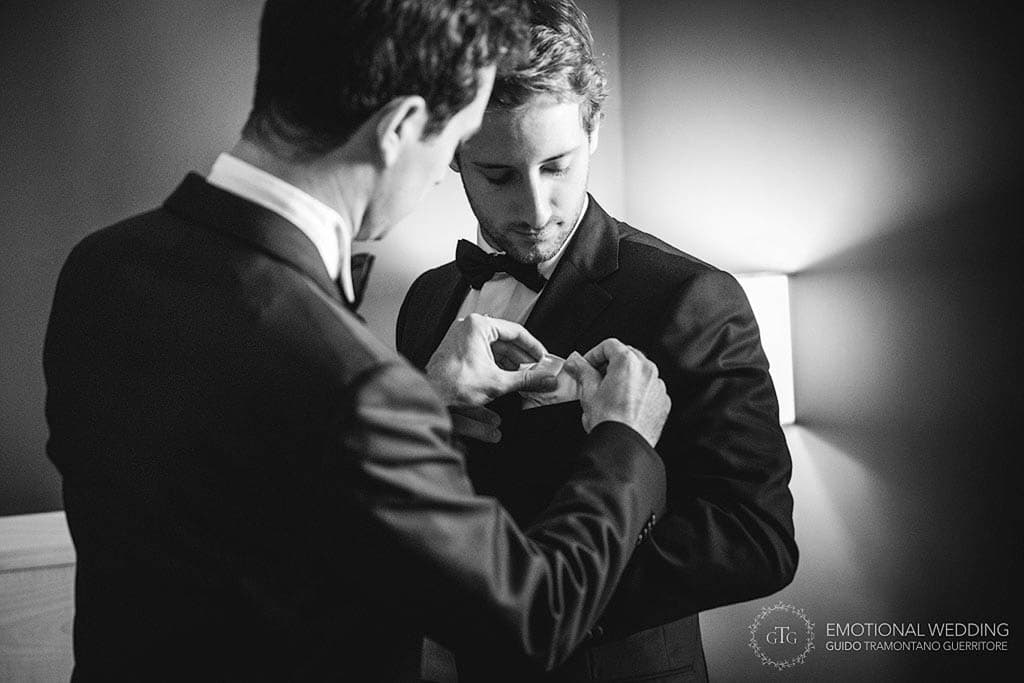 groom helping best man getting ready at a wedding in puglia
