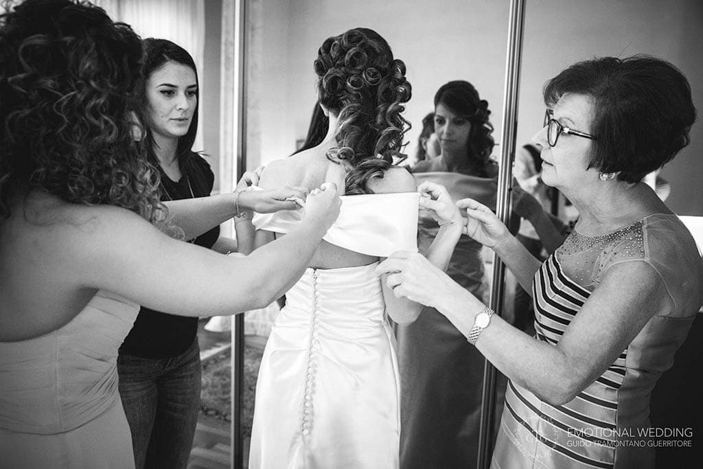 bride gets help getting ready for her wedding in apulia