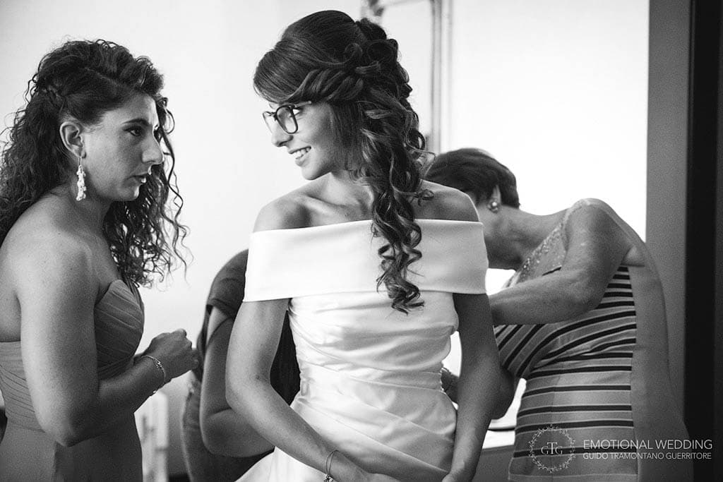 mother of the bride helps the bride getting ready for the wedding ceremony in apulia