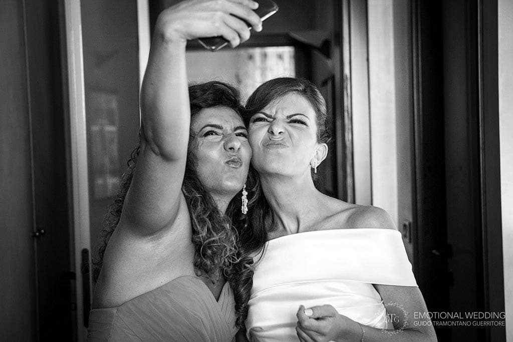 bride and bridesmaid taking a funny selfie at a wedding in apulia
