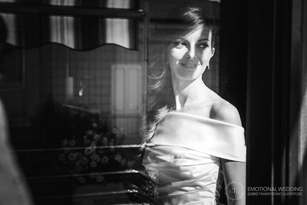 candid shot of a bride looking out of the window taken by a wedding photographer in apulia