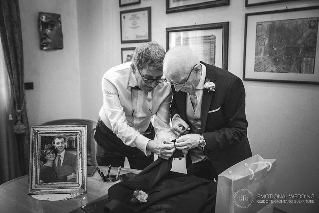 fathers of the bride and groom fixing a jacket at a wedding in apulia