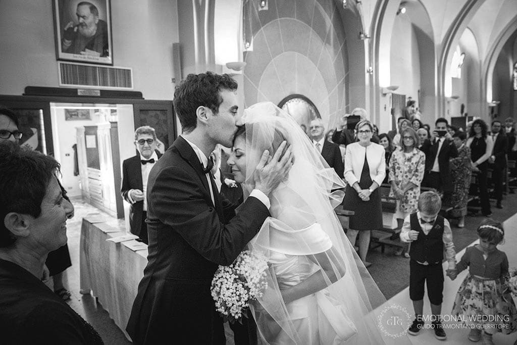 sposo bacia la sposa all'arrivo all'altare ad un matrimonio in puglia