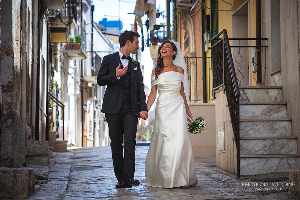 natural photo of bride and groom walking in the old town shot by a wedding photographer in apulia