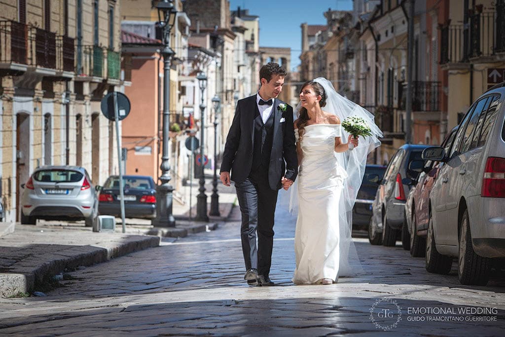 spontaneous shot of bride and groom walking in the streets taken by a wedding photographer in apulia