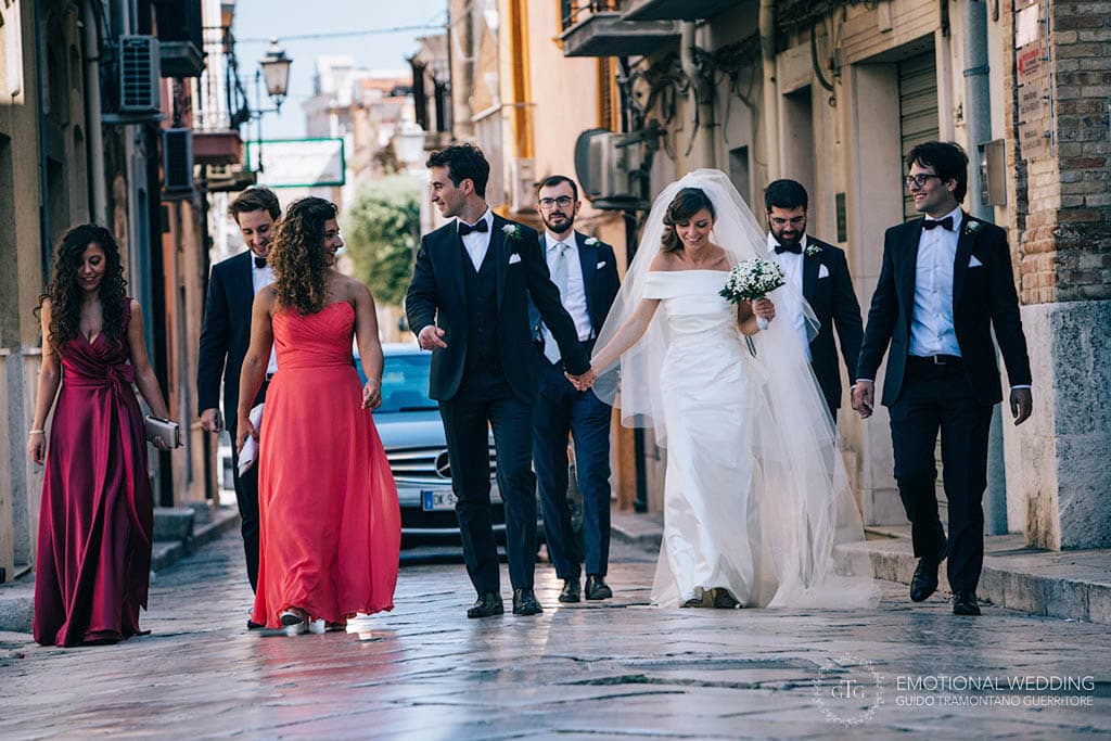 candid shot of bride and groom walking through an old town taken by a wedding photographer in puglia