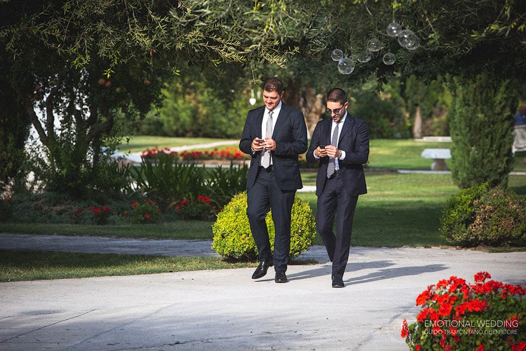 guests walking and looking at their smartphones at a wedding in apulia