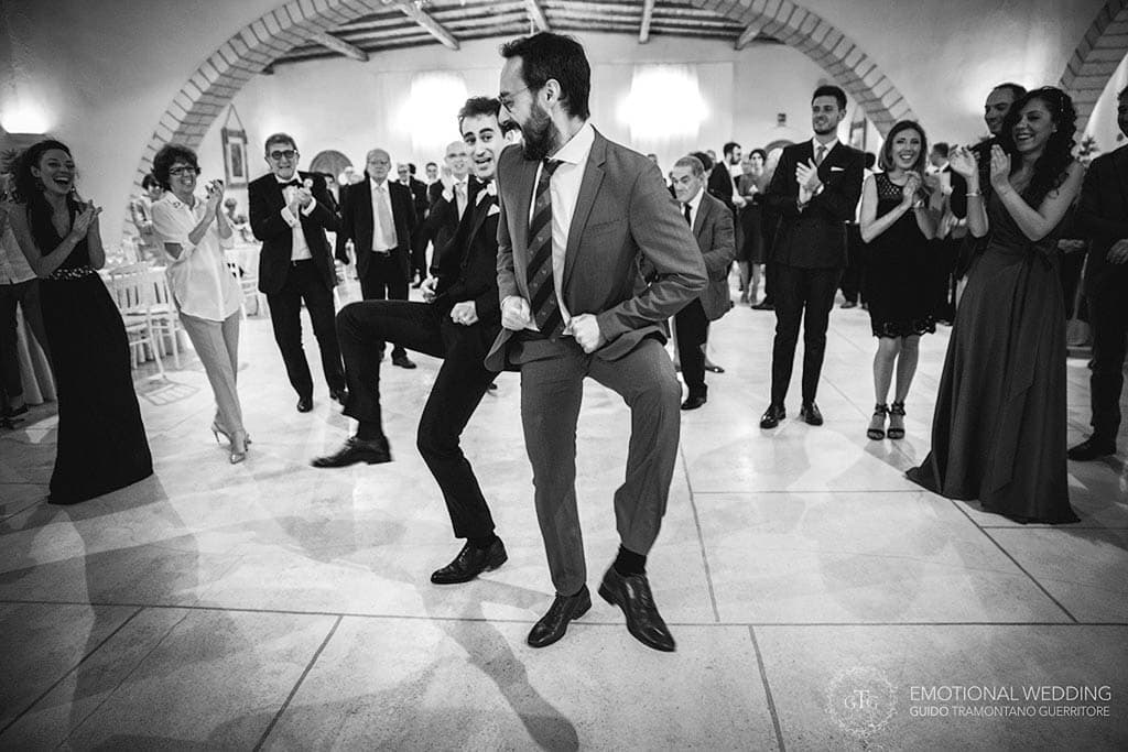 funny moment of the groom and a friend dancing at a wedding in Apulia