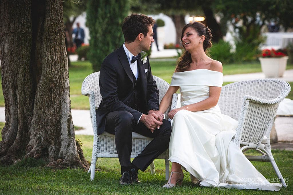candid shot showing the bride and groom relaxing in the garden of tenimento san Giuseppe, taken by a wedding photographer in apulia