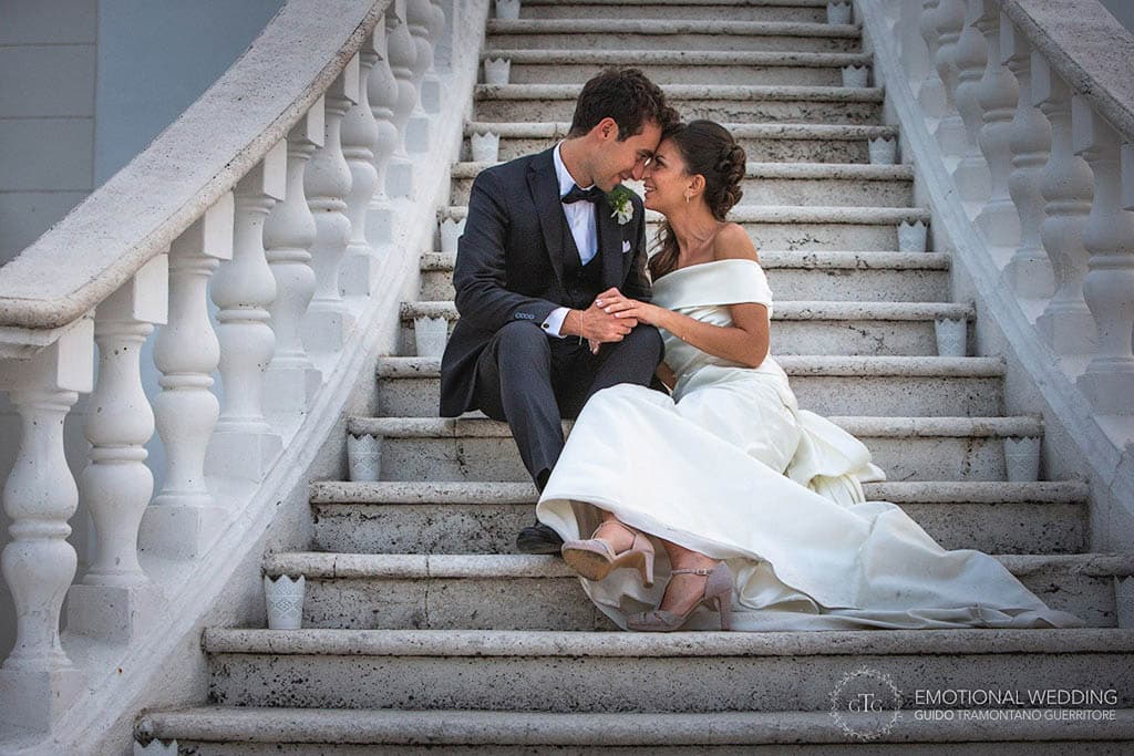 bride and groom sitting on the stairs face to face at tenimento san Giuseppe in apulia