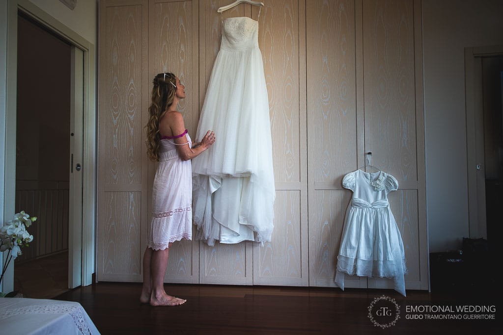 bride looking her wedding dress before getting ready for her wedding in cilento
