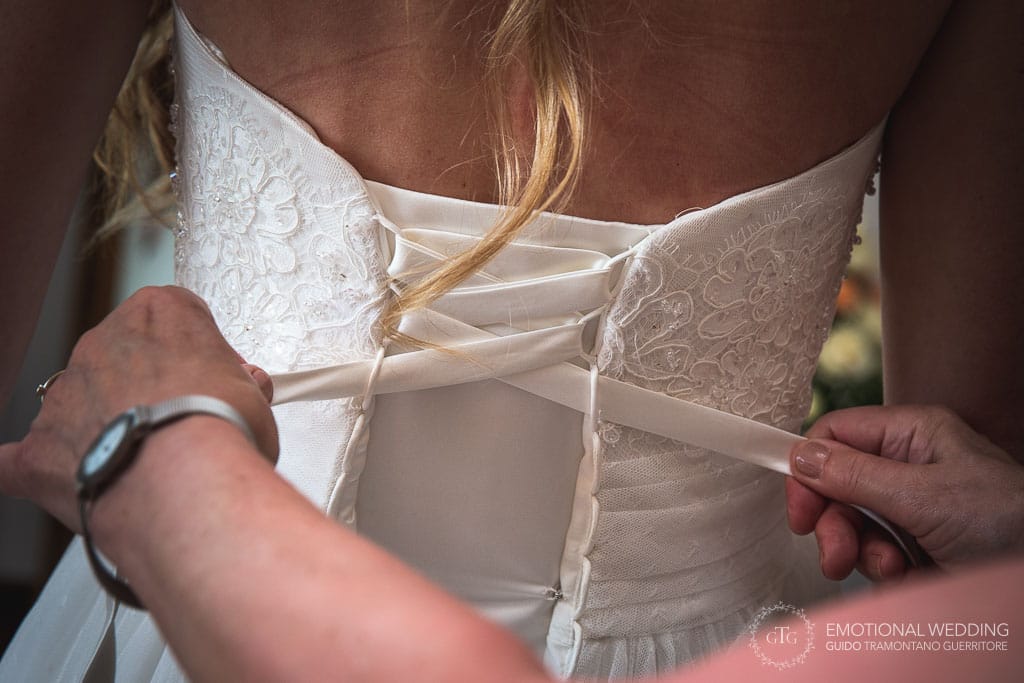close up of buttoning the wedding dress in cilento