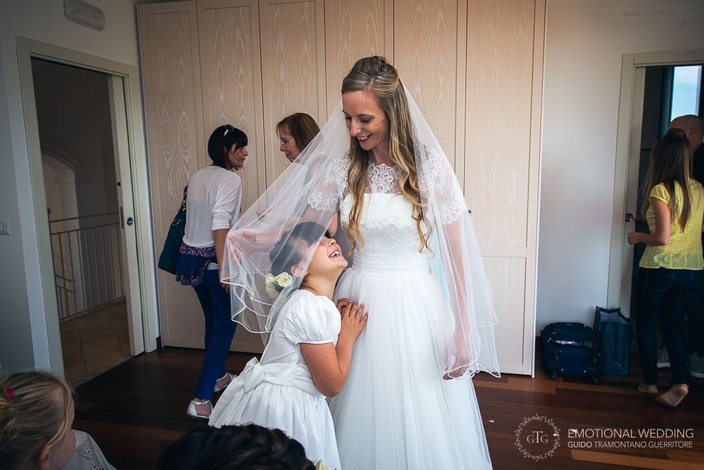 flower girl hugs the bride while she gets ready for her wedding in cilento