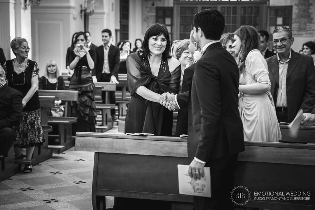 groom shaking hand to his mother after ceremony at Santa Maria church in Agropoli, Cilento