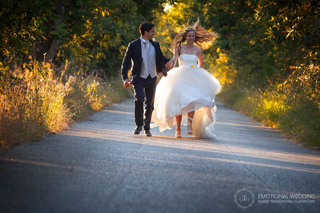 bride and groom running on a country road in Cilento national park