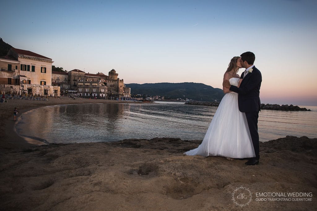 bride and groom kissing on a beach in Cilento