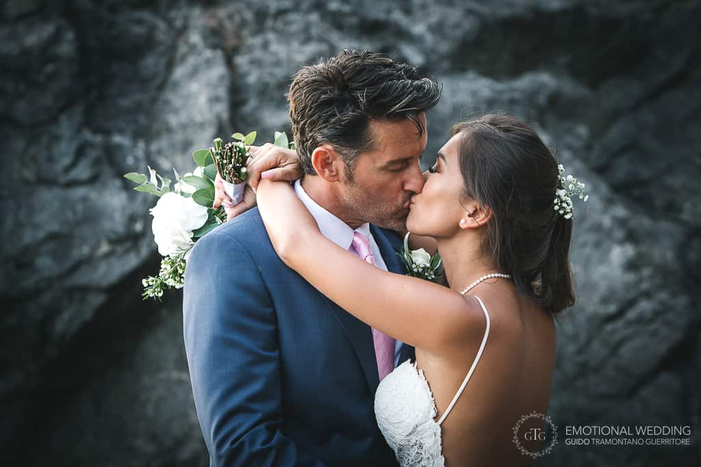 bacio degli sposi alla torre normanna a un matrimonio misto in costa d'Amalfi