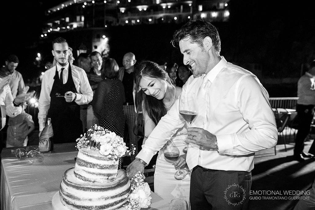 a mixed wedding couple in Amalfi coast cutting the cake