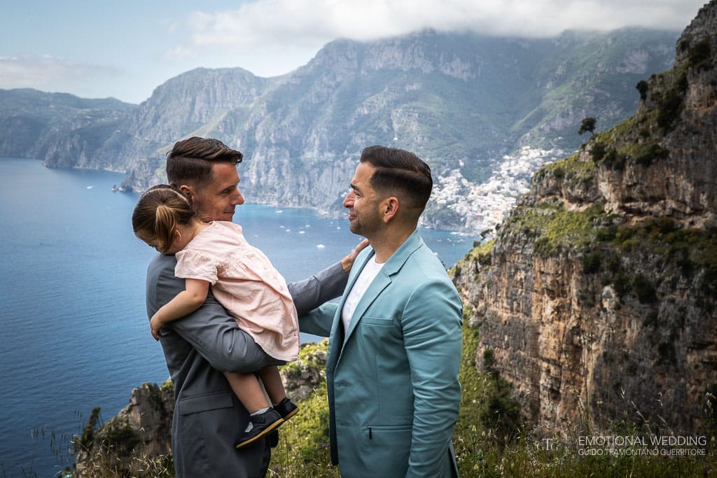 a gay couple and their daughter on the path of gods in Amalfi Coast