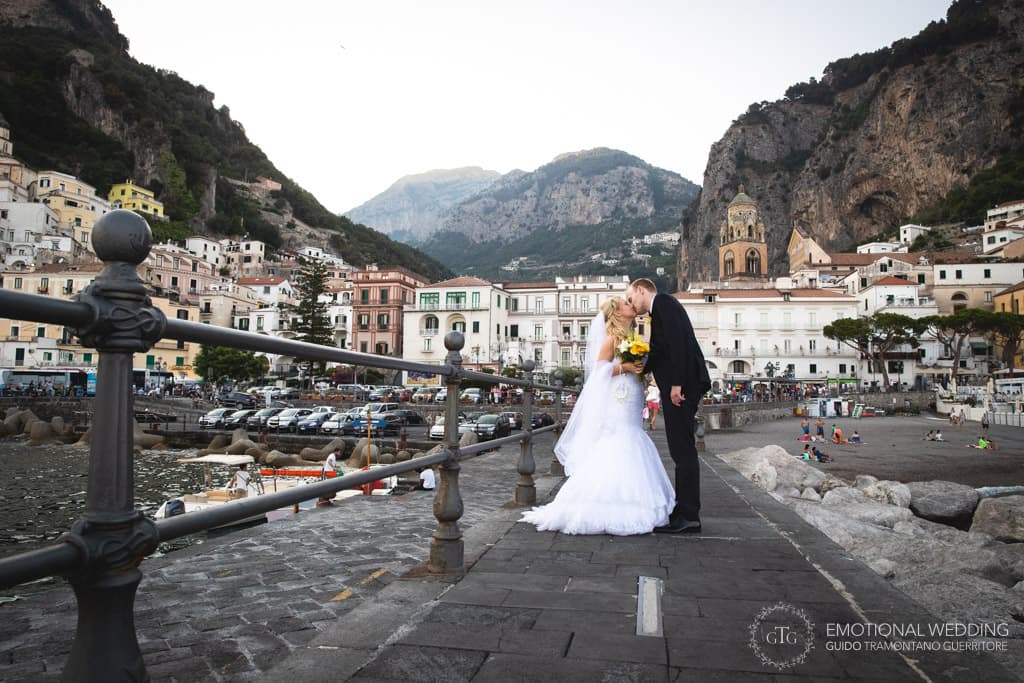 Candid shot of an irish couple kissing and Amalfi in the background