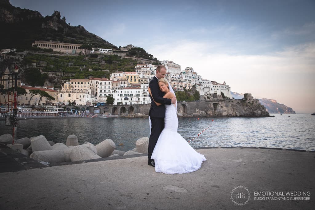 romantic portraiture of bride and groom and Atrani in the background shot by a wedding photographer in amalfi coast