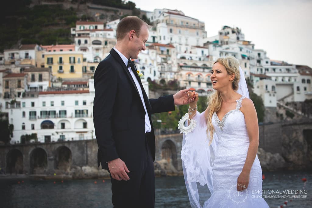 candid shot af bride and groom and atrani in the background in amalfi coast