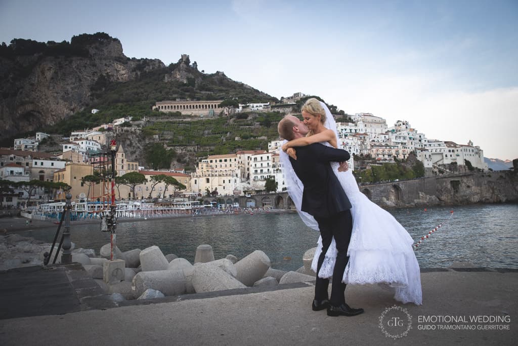 groom lifts the bride on the Amalfi pier in amalfi coast