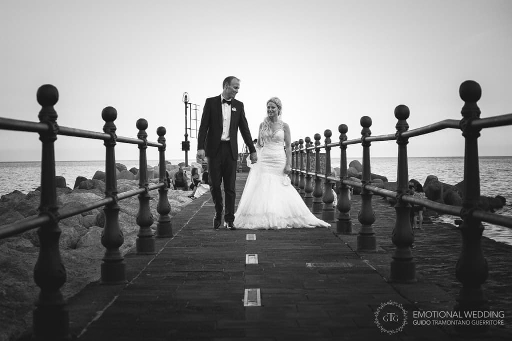 bride and groom walk on the pier in amalfi