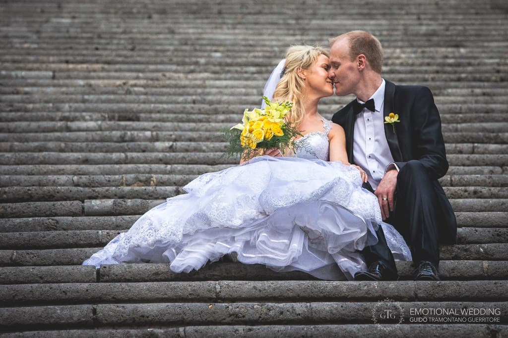 bride and groom kissing sitting down on the stairs of Amalfi cathedral