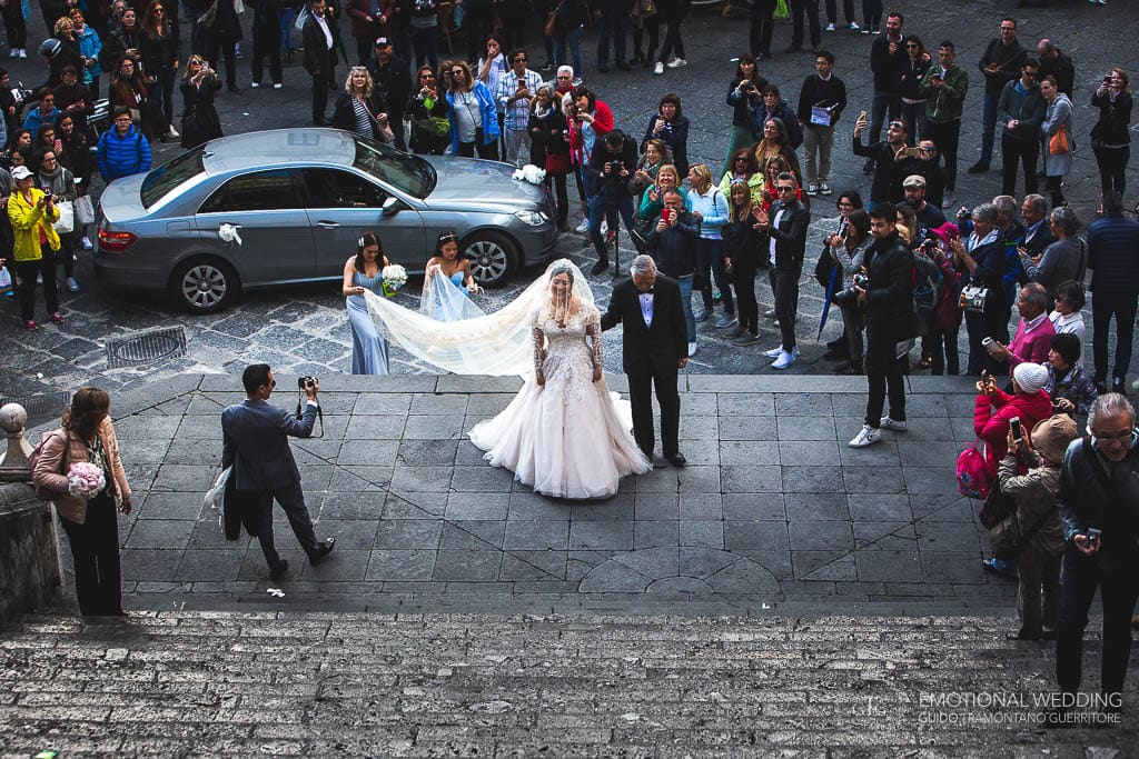 sposa esce dall'auto davanti al duomo di Amalfi per la cerimonia di matrimonio