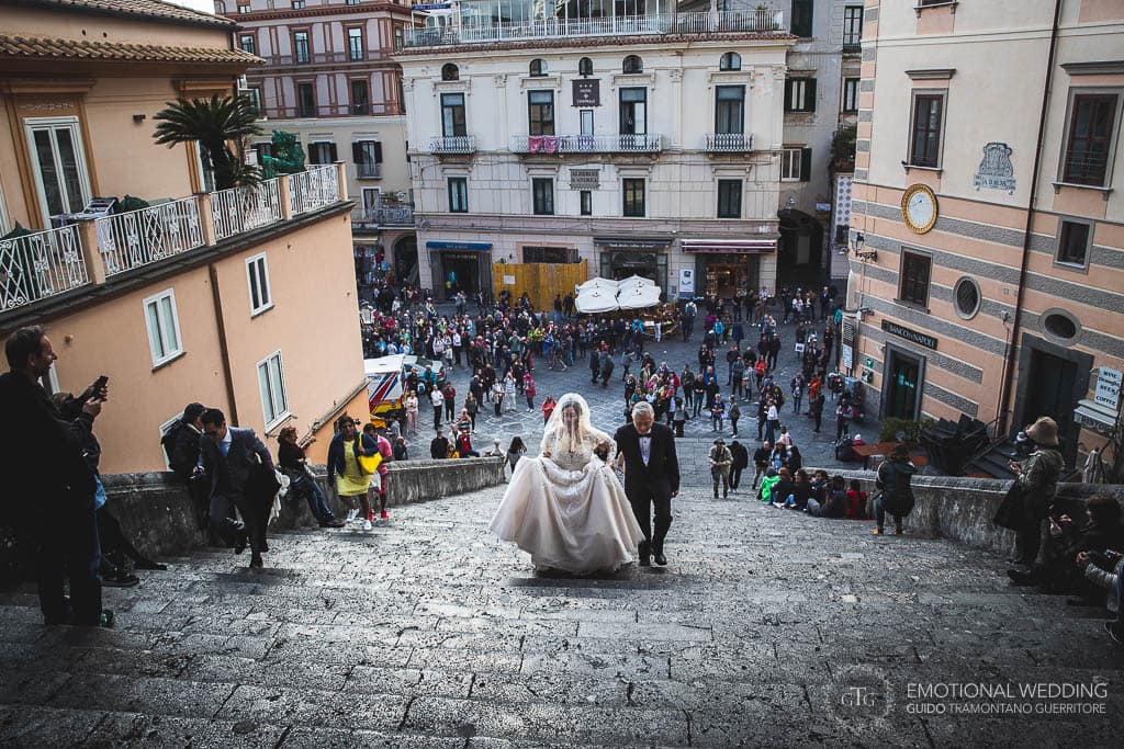 padre e sposa sulle gradinate del duomo di Amalfi vanno all'altare per la cerimonia di matrimonio