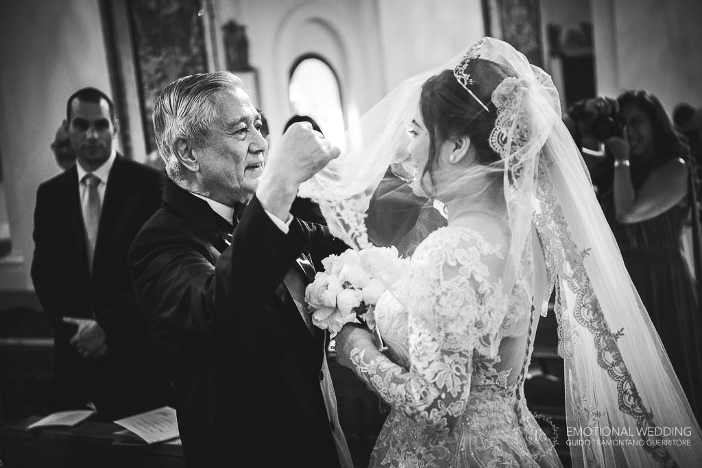 padre solleva il velo dal viso della sposa per la cerimonia di matrimonio al duomo di Amalfi