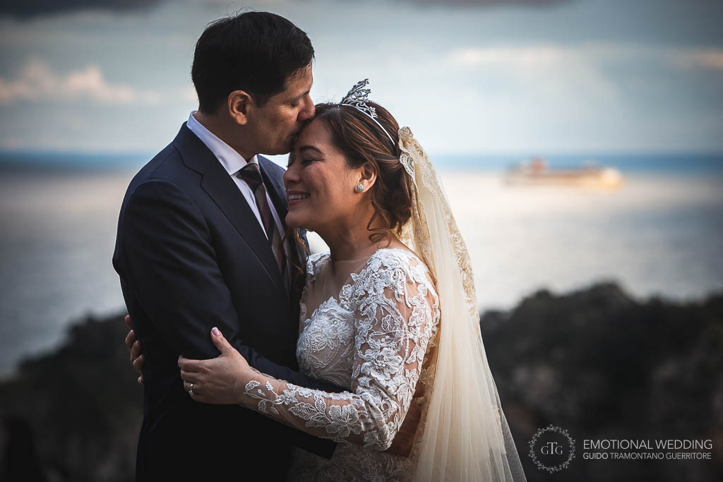 sposo bacia la sposa sulla fronte ad un matrimonio a praiano