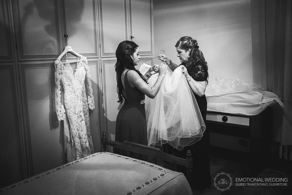 bridesmaid and mother of the bride checking the wedding dress