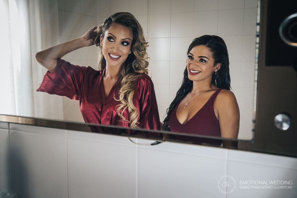 bride and bridesmaid smiling while getting ready at a destination wedding