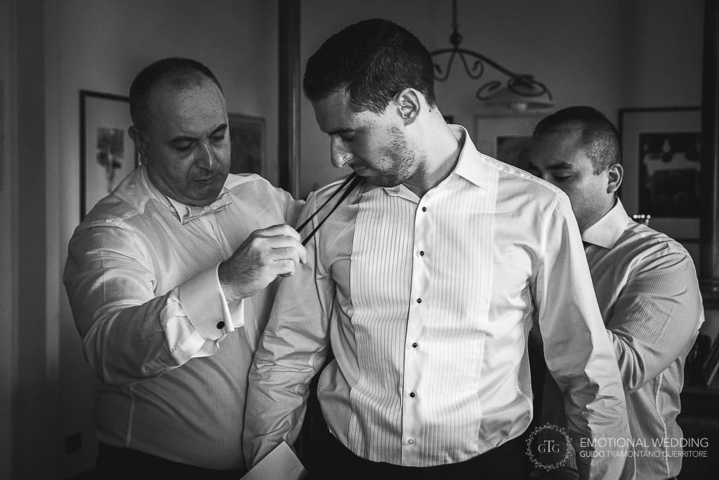 groom gets help getting ready