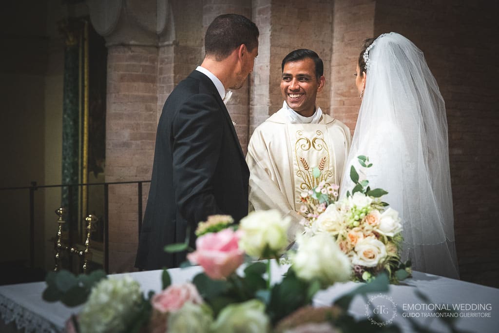 sposi e parroco sorridono dopo la cerimonia nella cattedrale di fidenza