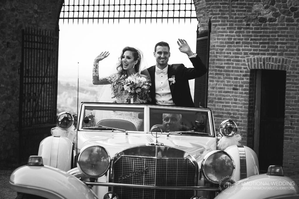 sposi arrivano in auto d'epoca al castello di tabiano per il ricevimento del loro matrimonio a fidenza