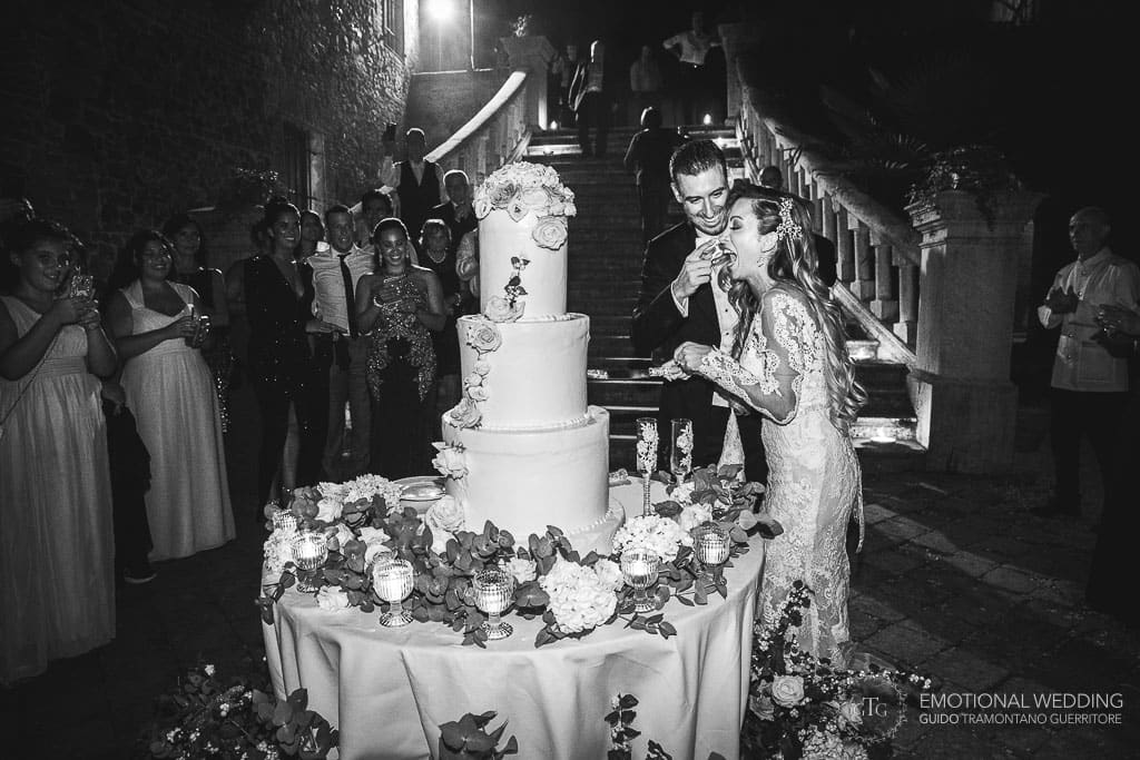 groom puts cake in bride's mouth at a destination wedding