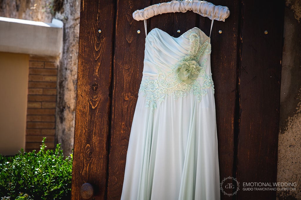 wedding dress hanged on a wooden door in ravello, italy